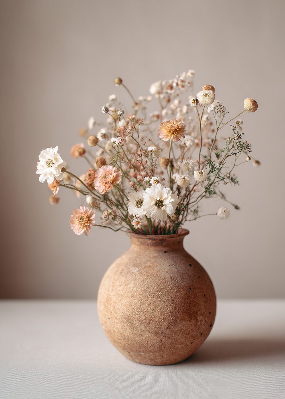 Pastellbukett i rund terrakottavas med vårblommor, perfekt för botaniska posters och vårdekoration.