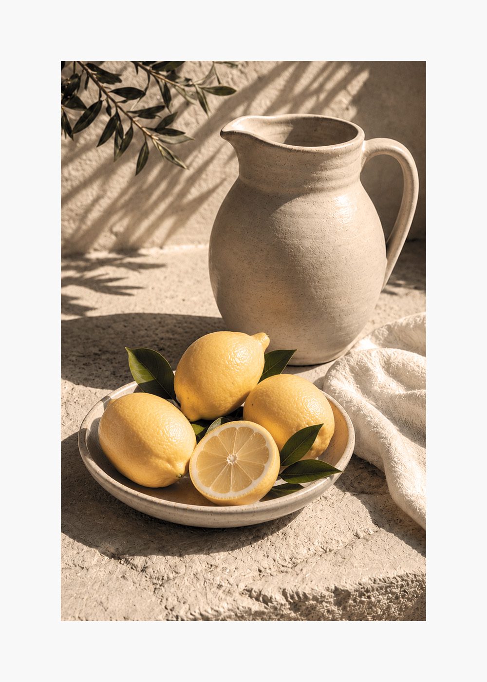 Citroner i skål vid rustik kanna, kökstavla sommarposter.